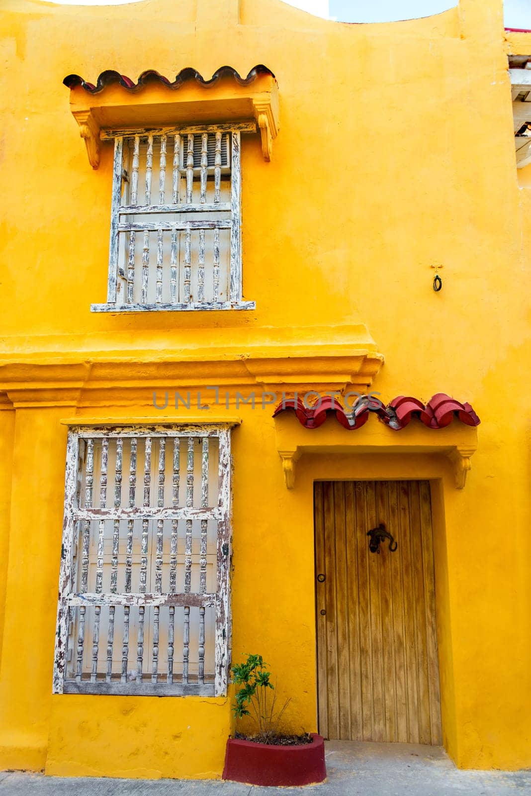 Windows and door of a yellow colonial building in the historic center of Cartagena, Colombia