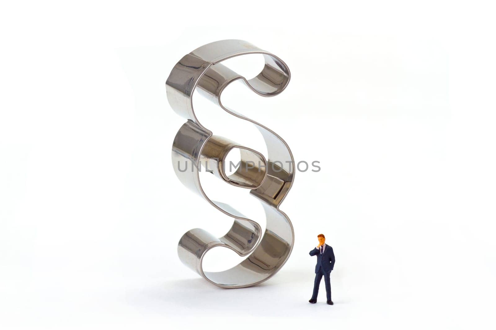 Miniature figure with paragraph characters on a light background
