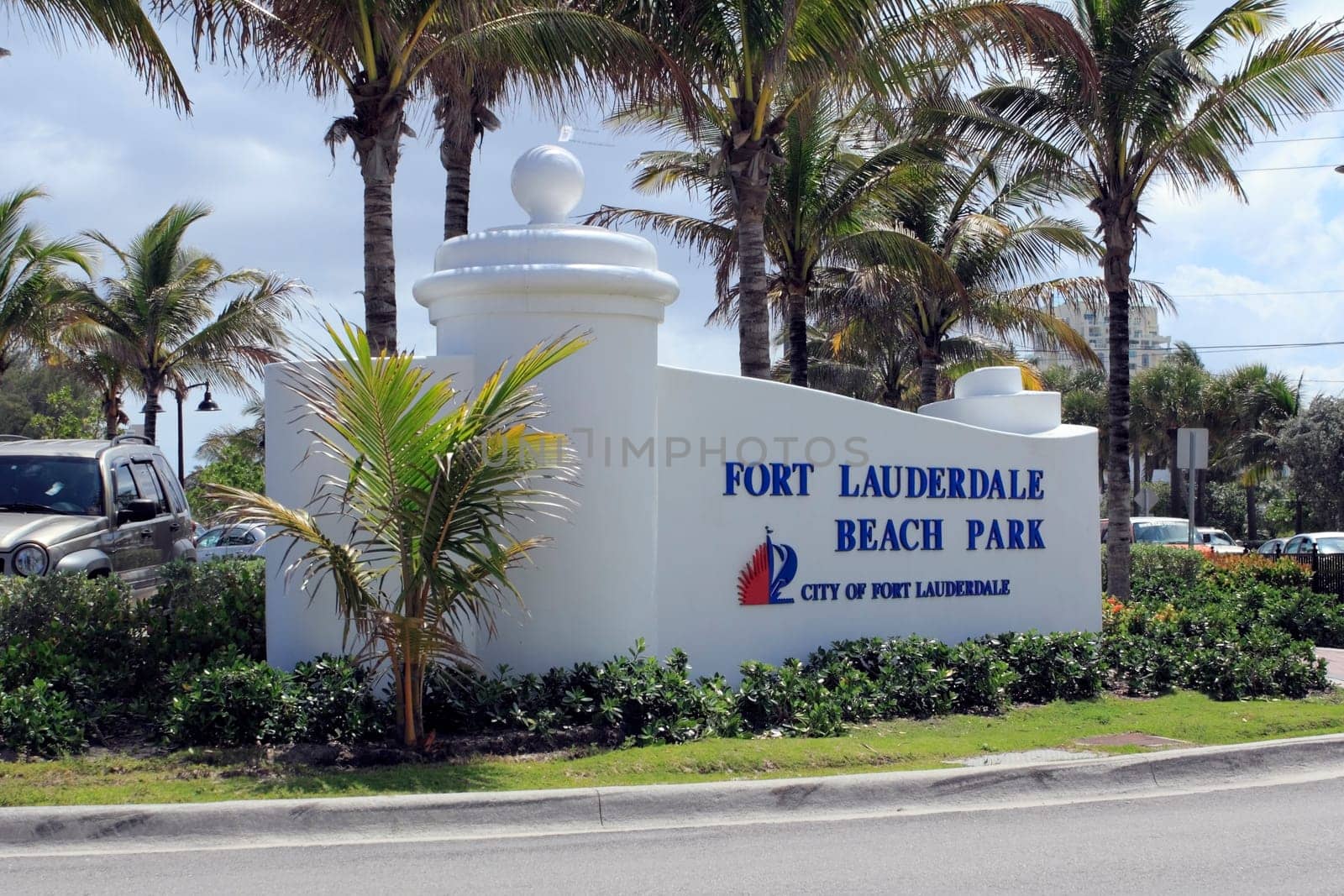 FORT LAUDERDALE, FLORIDA - APRIL 6, 2013: Closeup of Ft Lauderdale Beach Park sign with palm trees and autos in the background. Location is at 1100 Seabreeze Boulevard and is open 5 AM to midnight.