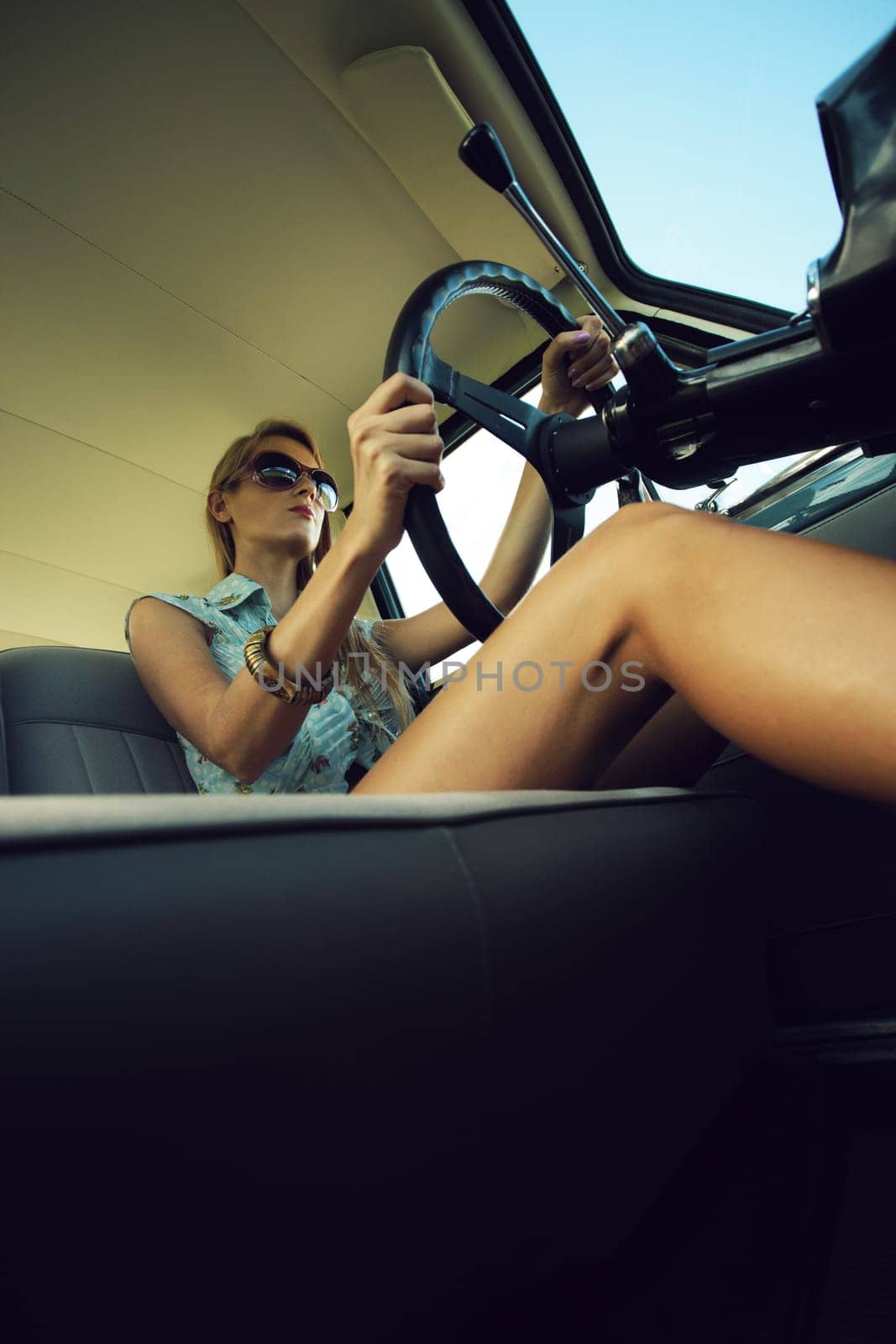 Beautiful young woman driving vintage car.