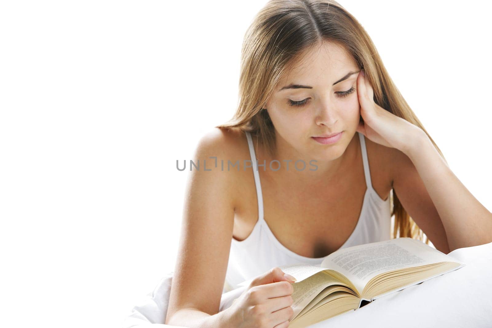 Young beautiful woman reading in bed