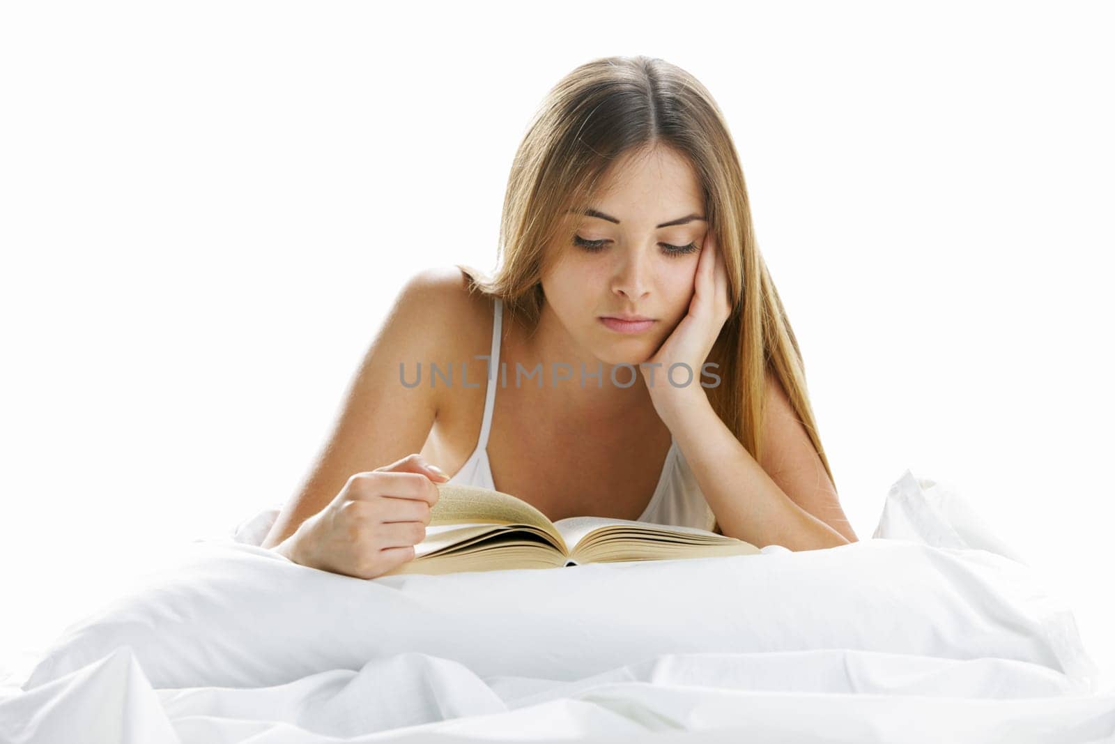 Young beautiful woman reading in bed