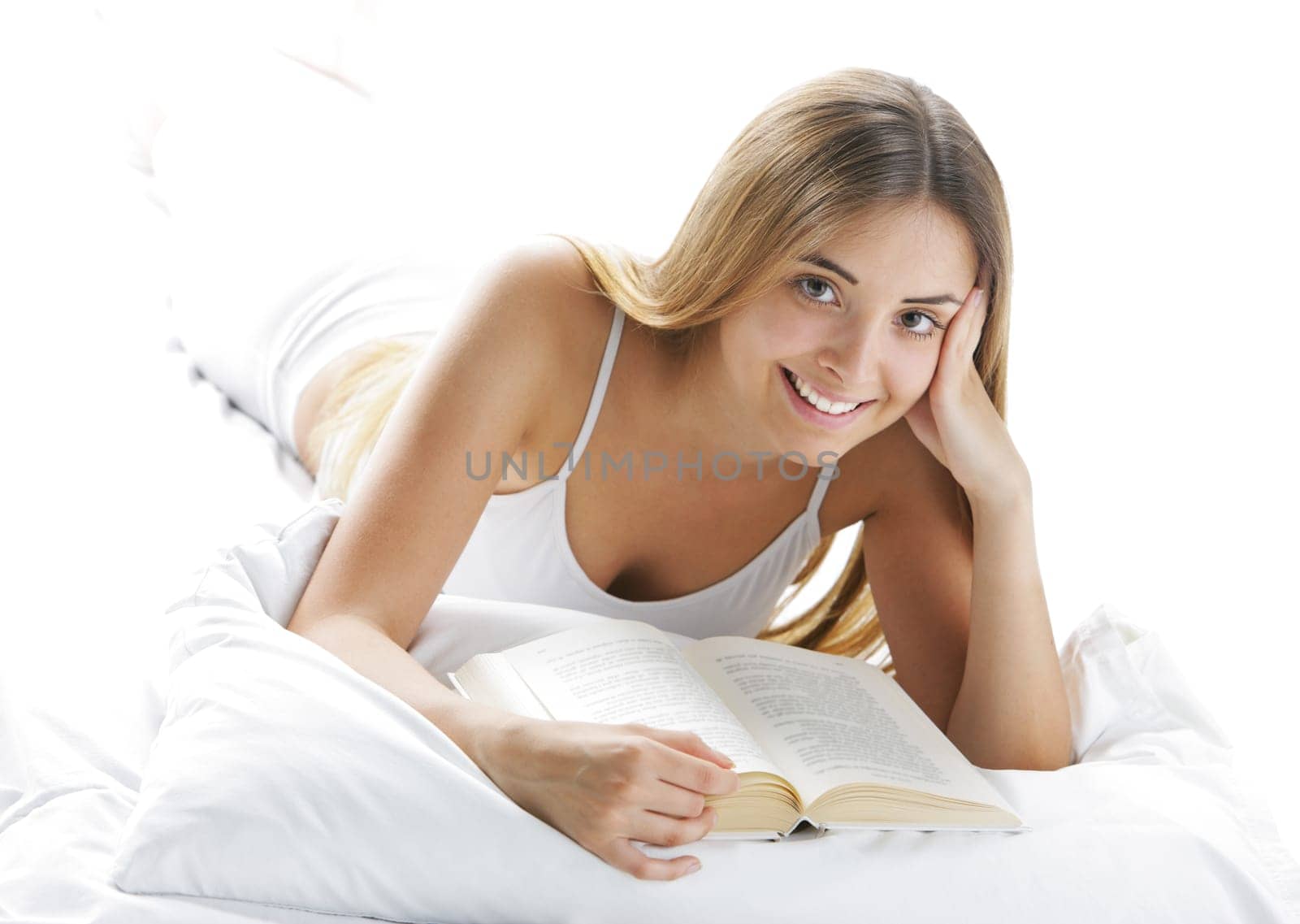 Young smiling woman reading in bed