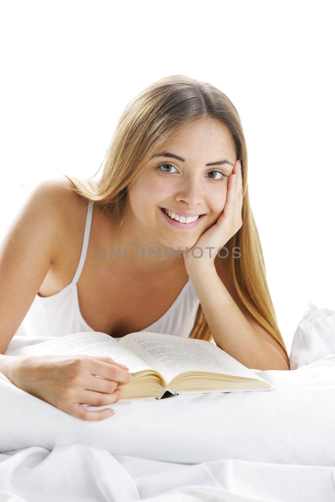 Young smiling woman reading in bed
