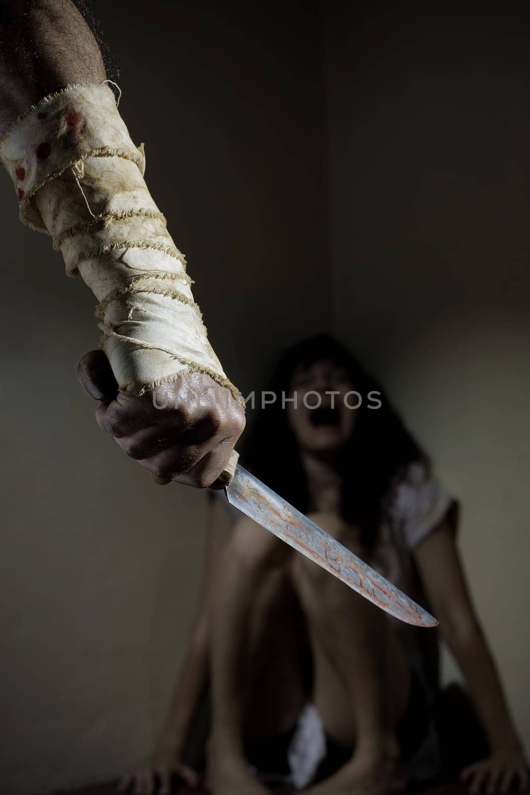 Scared woman threatened by a man with bloody knife