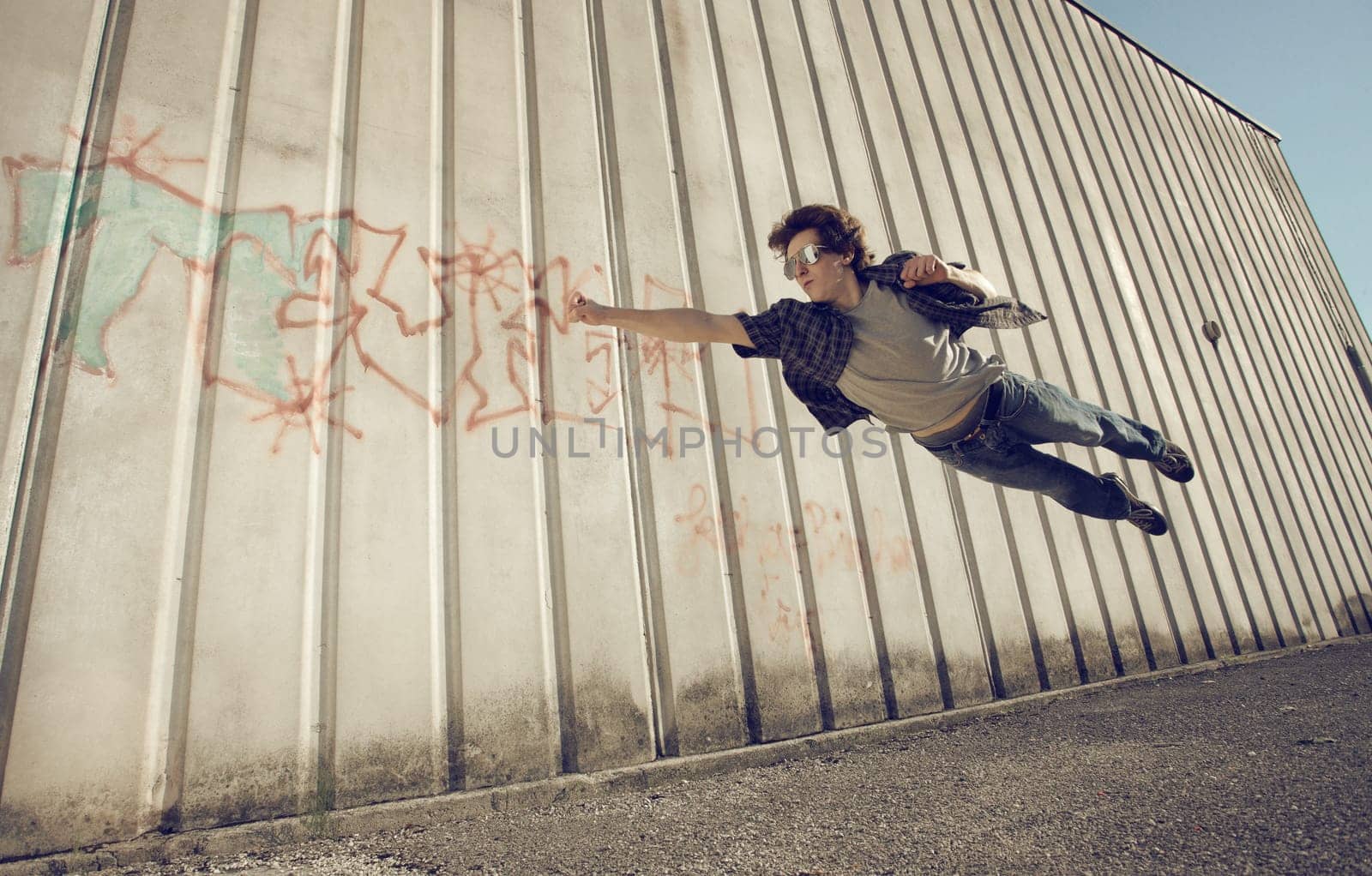 Young man feels like a superhero, flying free.