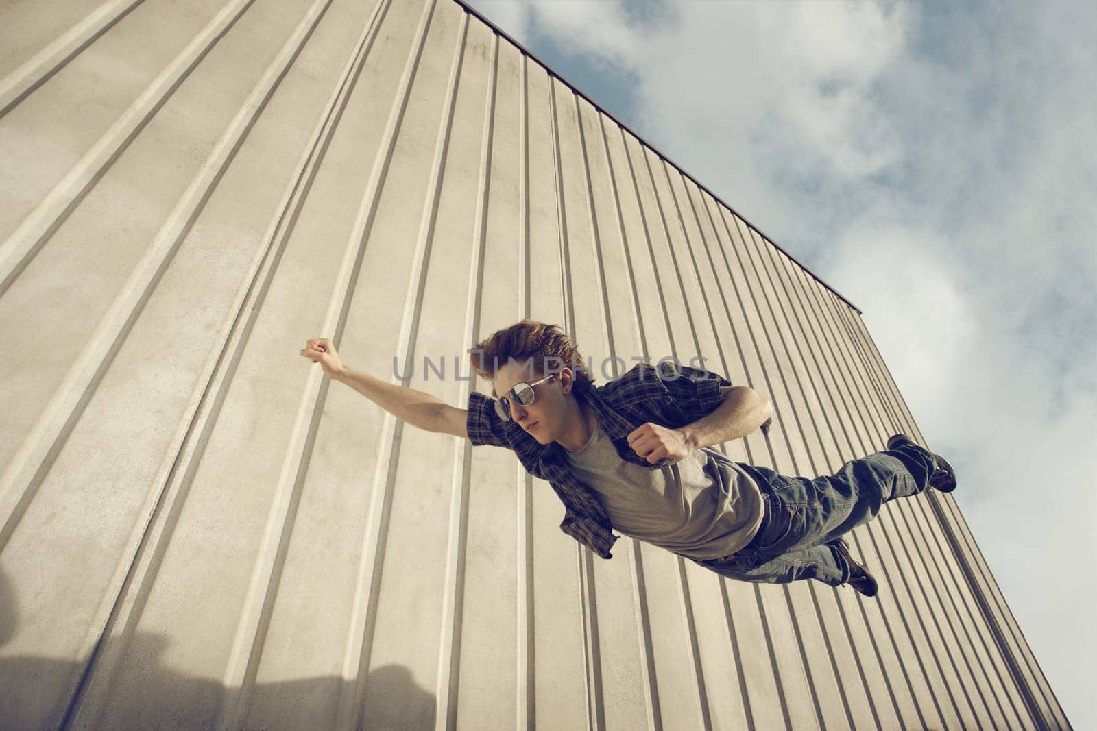 A young man feels like a superhero, flying free.