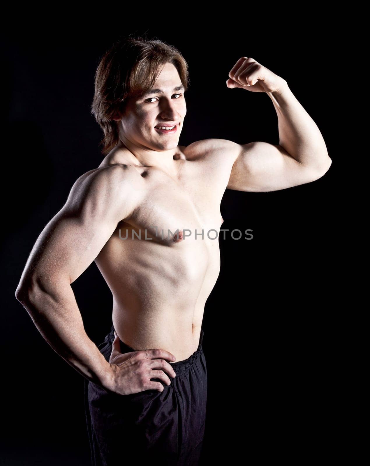 Sexy muscular male athlete showing biceps