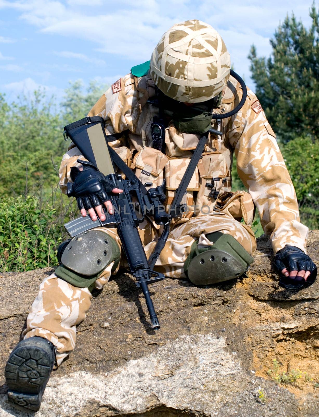 British soldier in desert uniform sitting wounded
