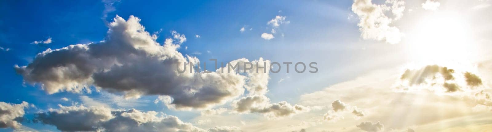 Sunset sunrays in a blue cloudy sky