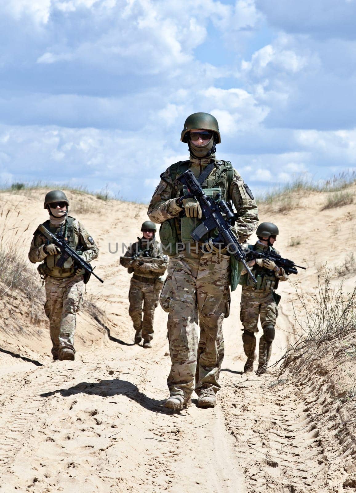 Squad of soldiers patrolling across the desert
