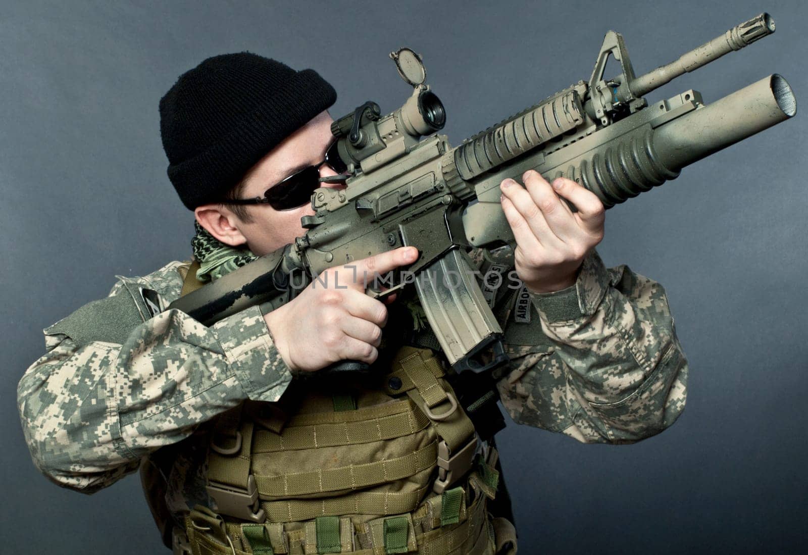 US soldier in black goggles aiming with his rifle