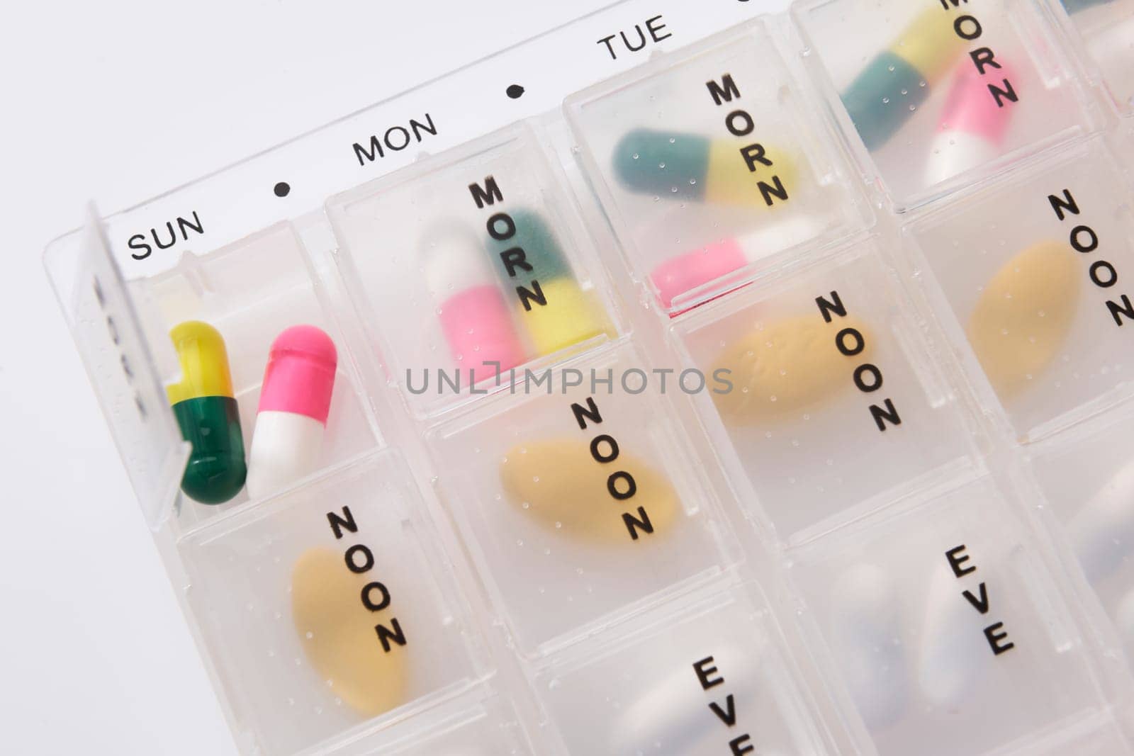 Different types of pills in a weekly dosage container