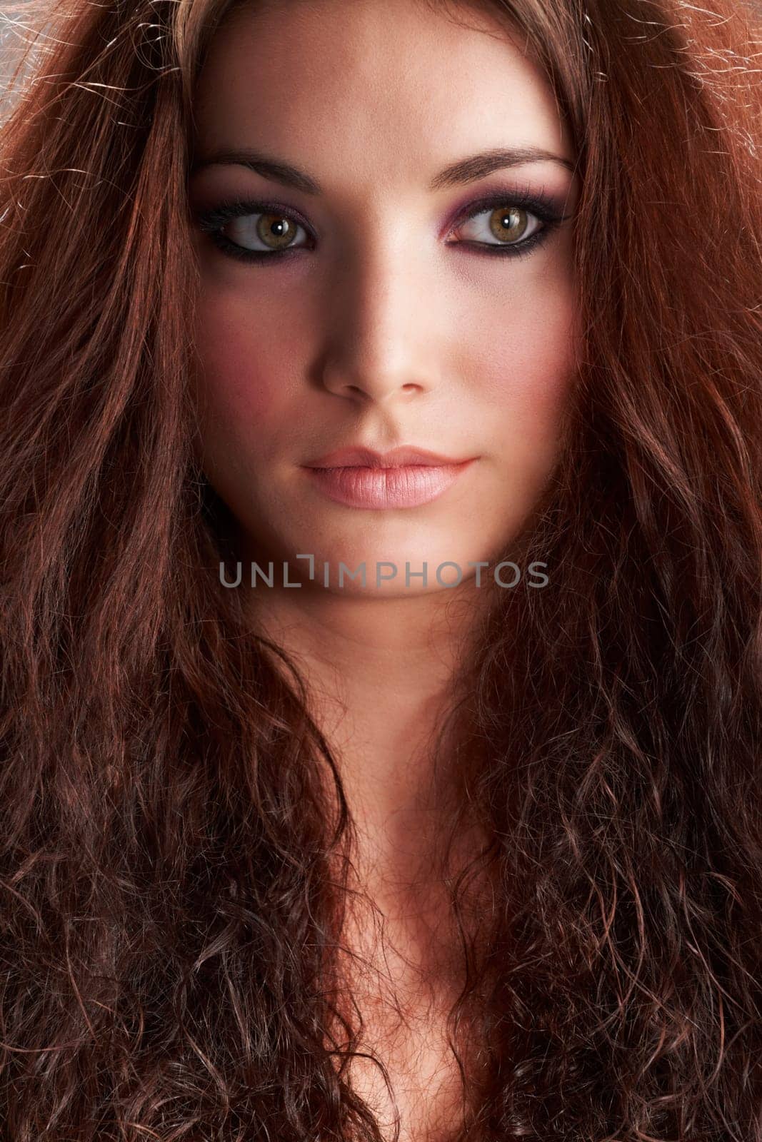 Portrait of beautiful young woman with make-up on grey background