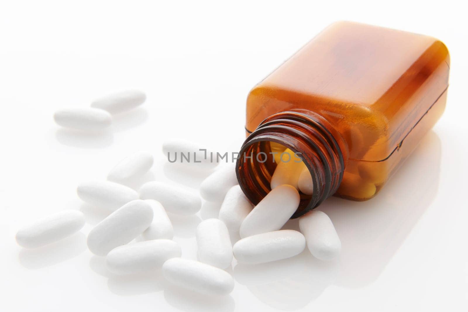 pills spilling out of bottleon white background with space for copy