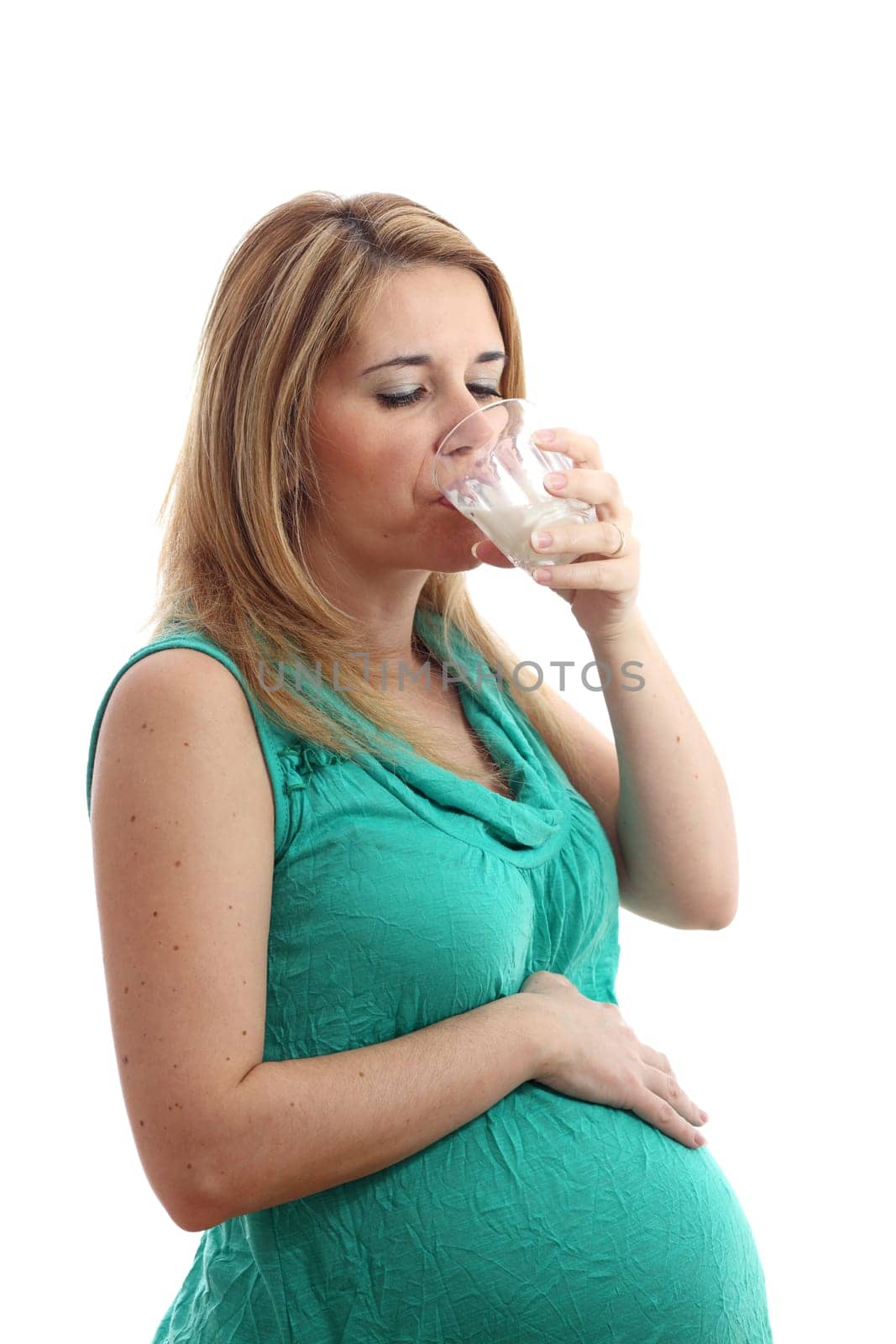 Details of a pregnant woman with a glass of milk isolated on white background.