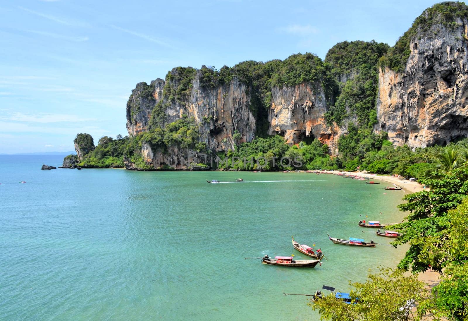 Ton Sai Beach on a sunny day with longtail boats as soon from a climbing wall
