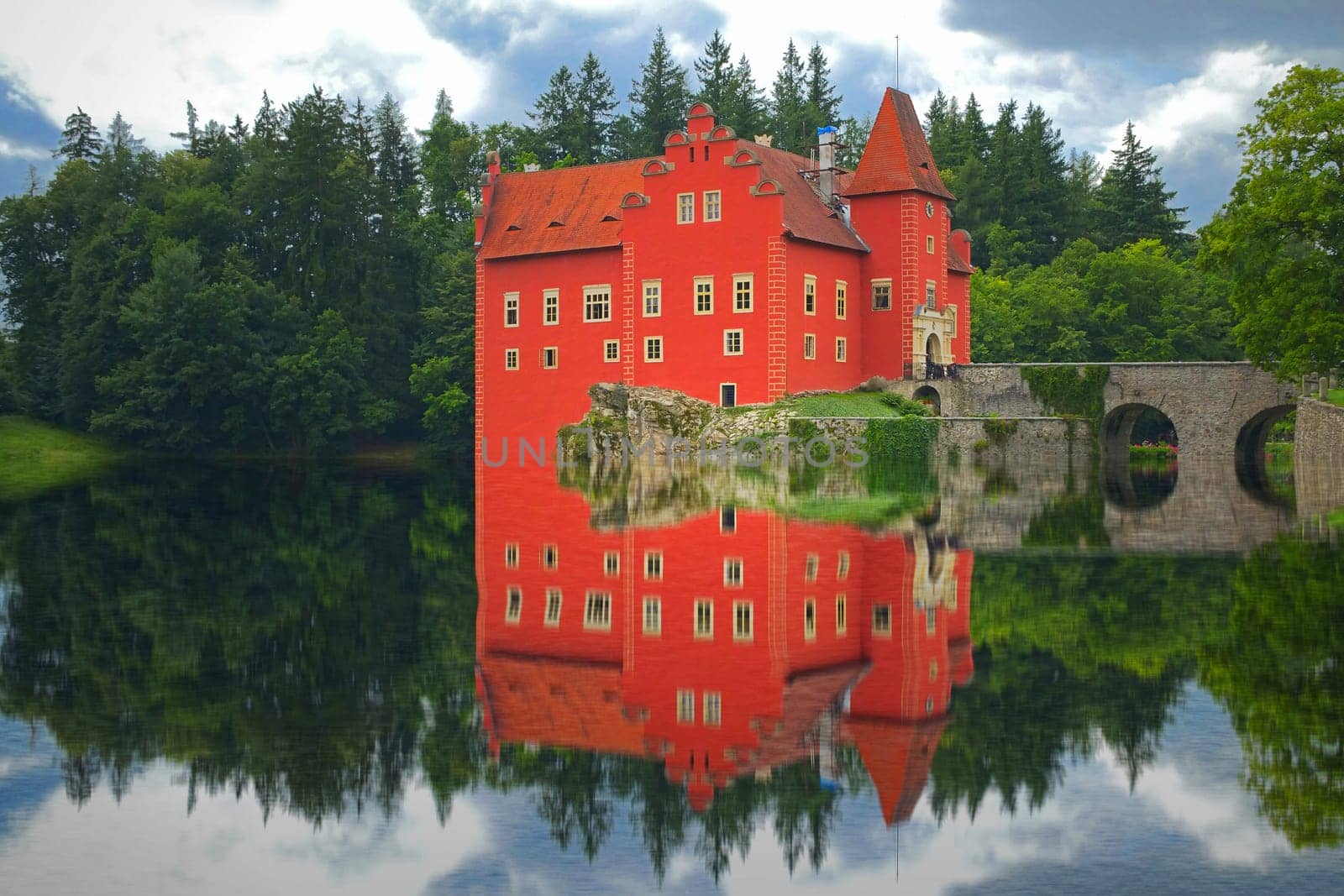 Reflection of the red castle on the lake. State castle Cervena Lhota, Czech Republic)