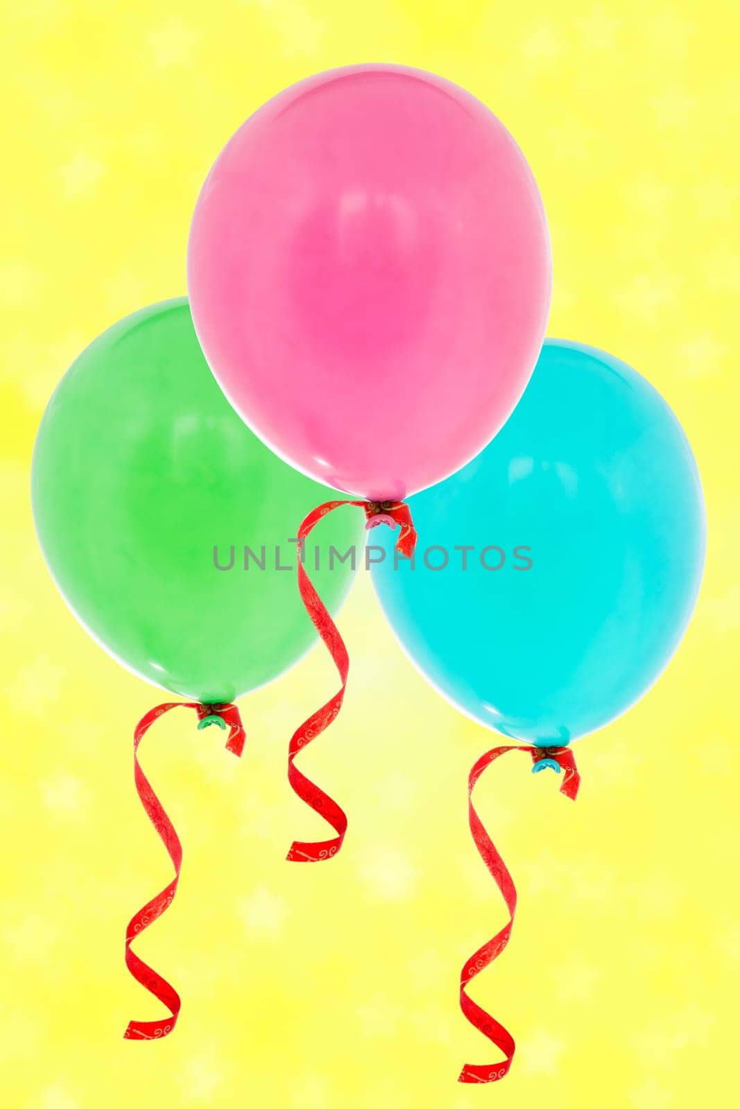 Colorful inflatable balloons flying on the yellow background