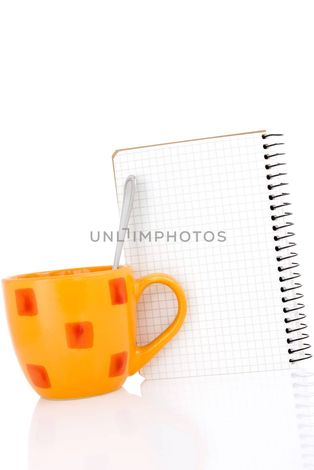 Orange coffee cup with a notebook on white background