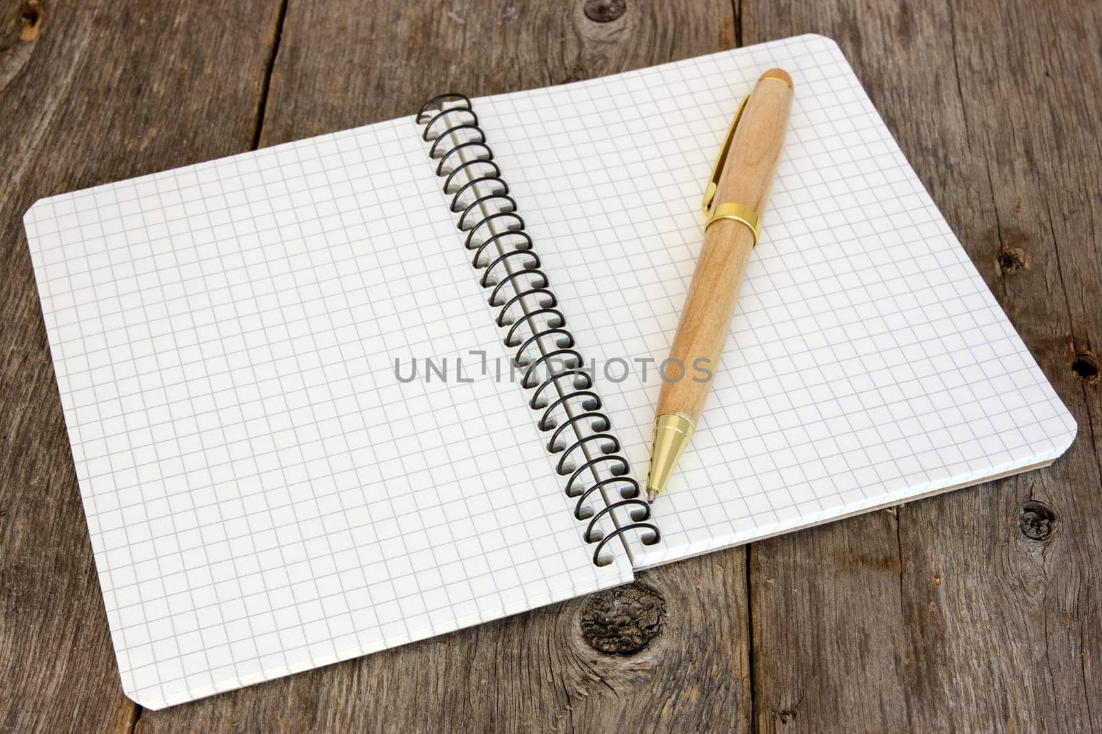 Notebook with a pen on the old wooden floor