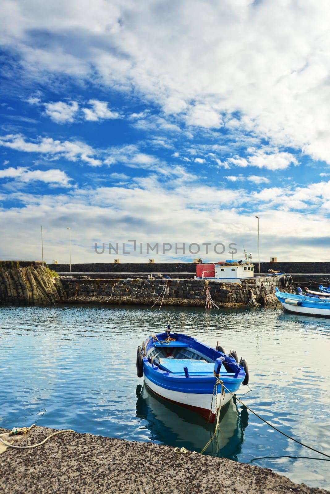 Fishing Boat, color blue white, moored along the quay on a cloudy day