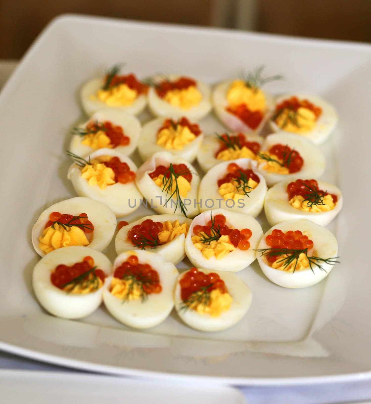 Dish with red caviar in a chicken egg