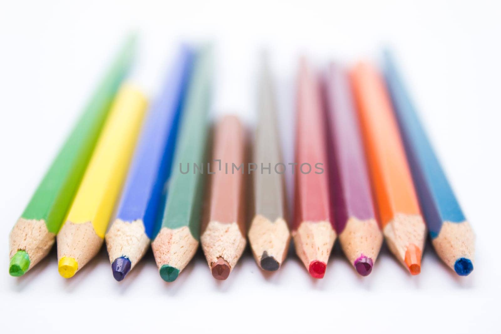 Different color pencils arranged on a white background.
