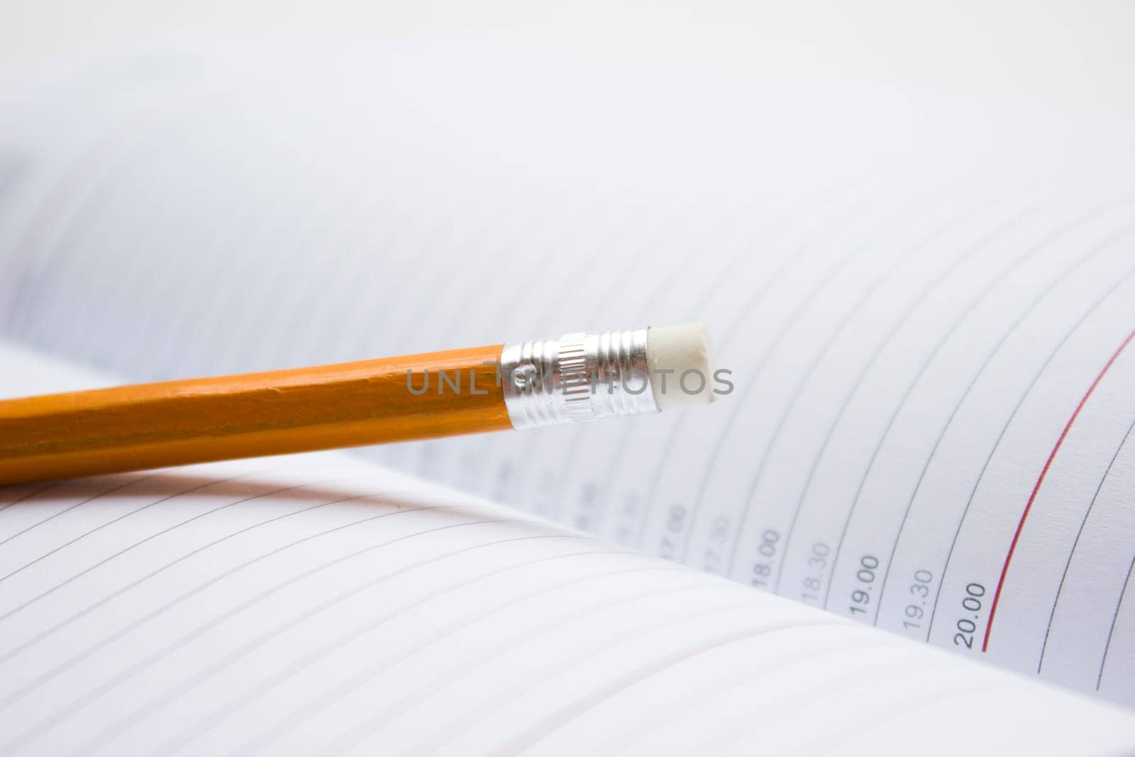 Pencil in a composition with a blank book with hardcovers.