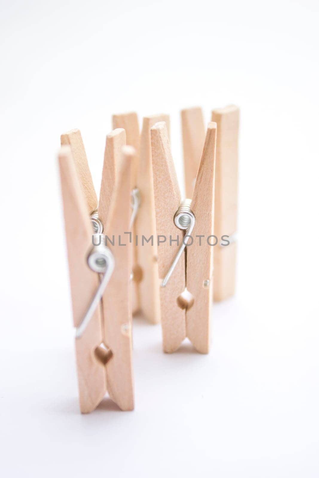 Composition of several wooden pegs on a white background.