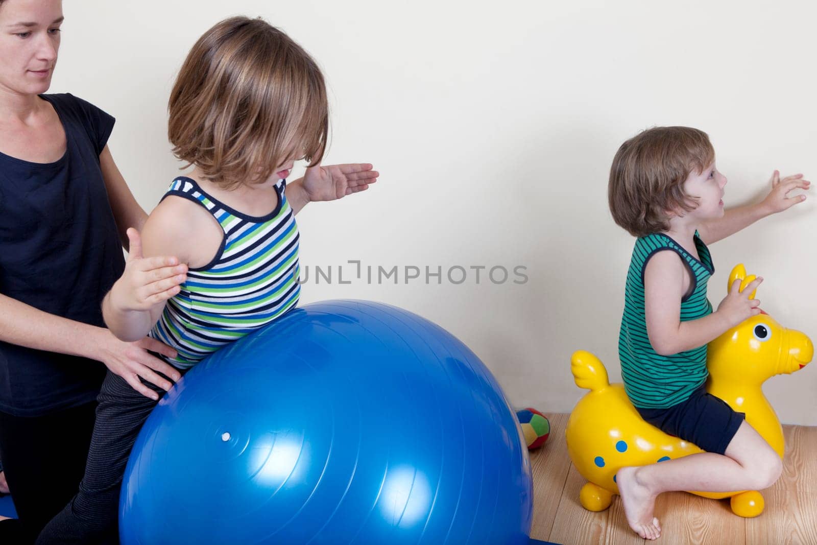 Children do gymnastics on a ball, a physical therapist shows exercises for the back