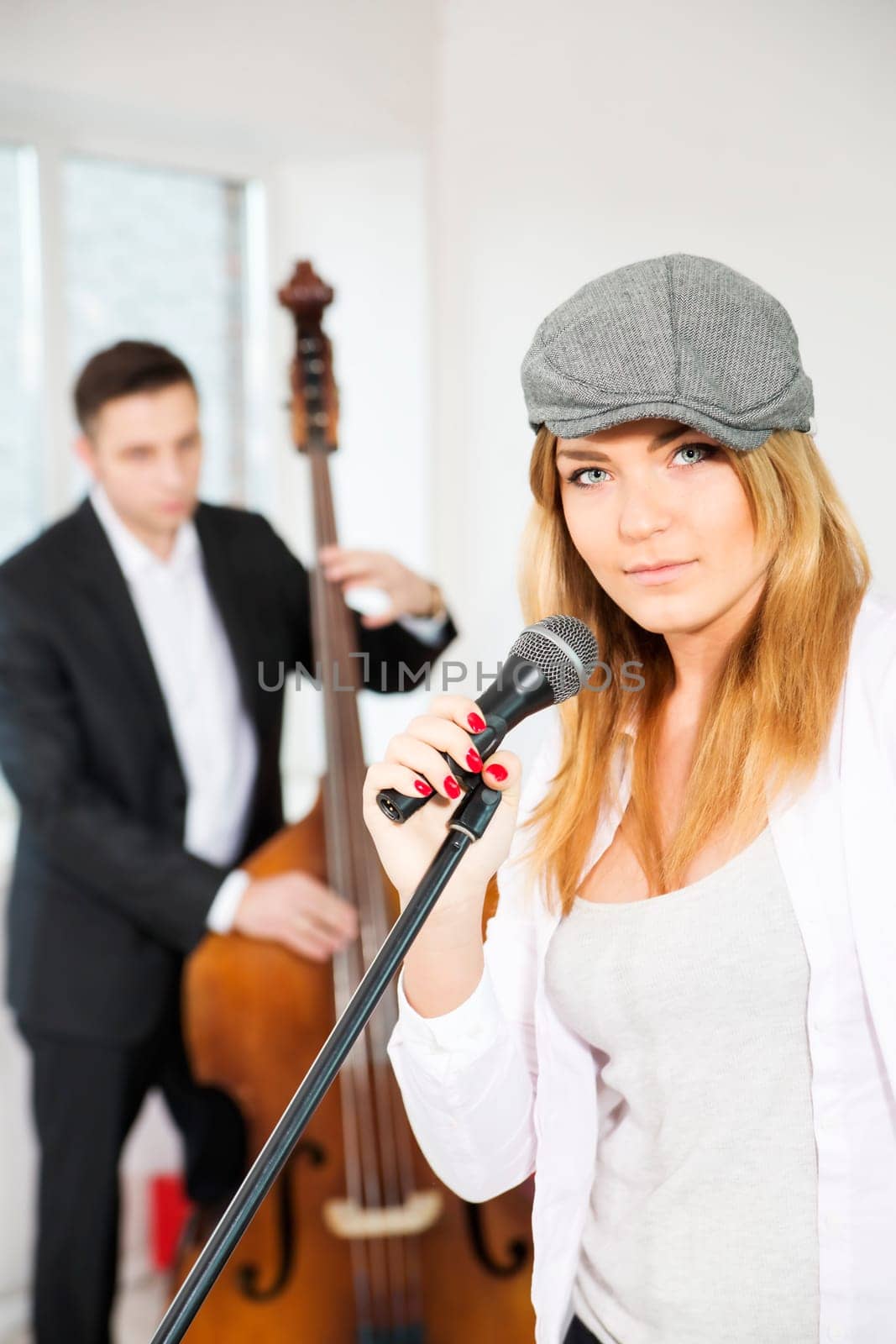 Woman next to microphone and man with contrabas