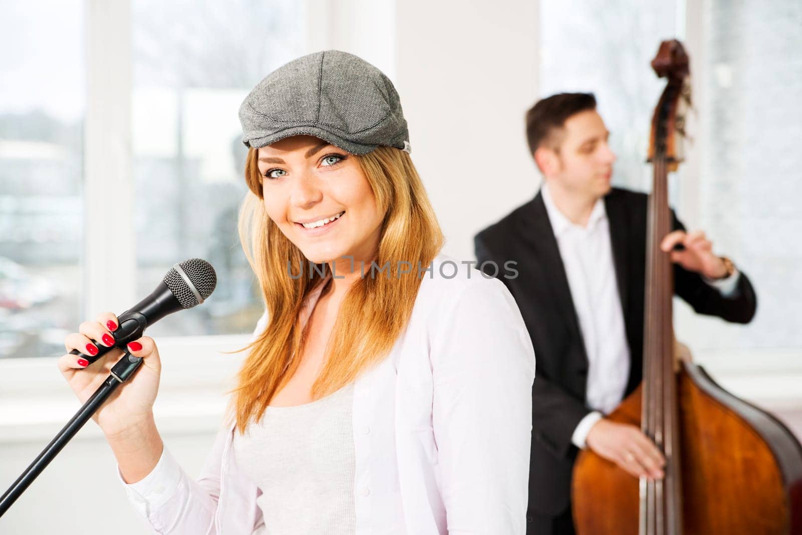 Woman with microphone and man play on contrabas