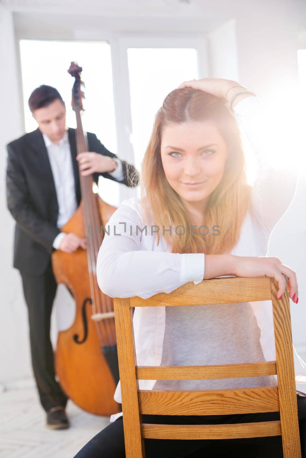 Beatiful woman backwards on wooden chair fondled hairs