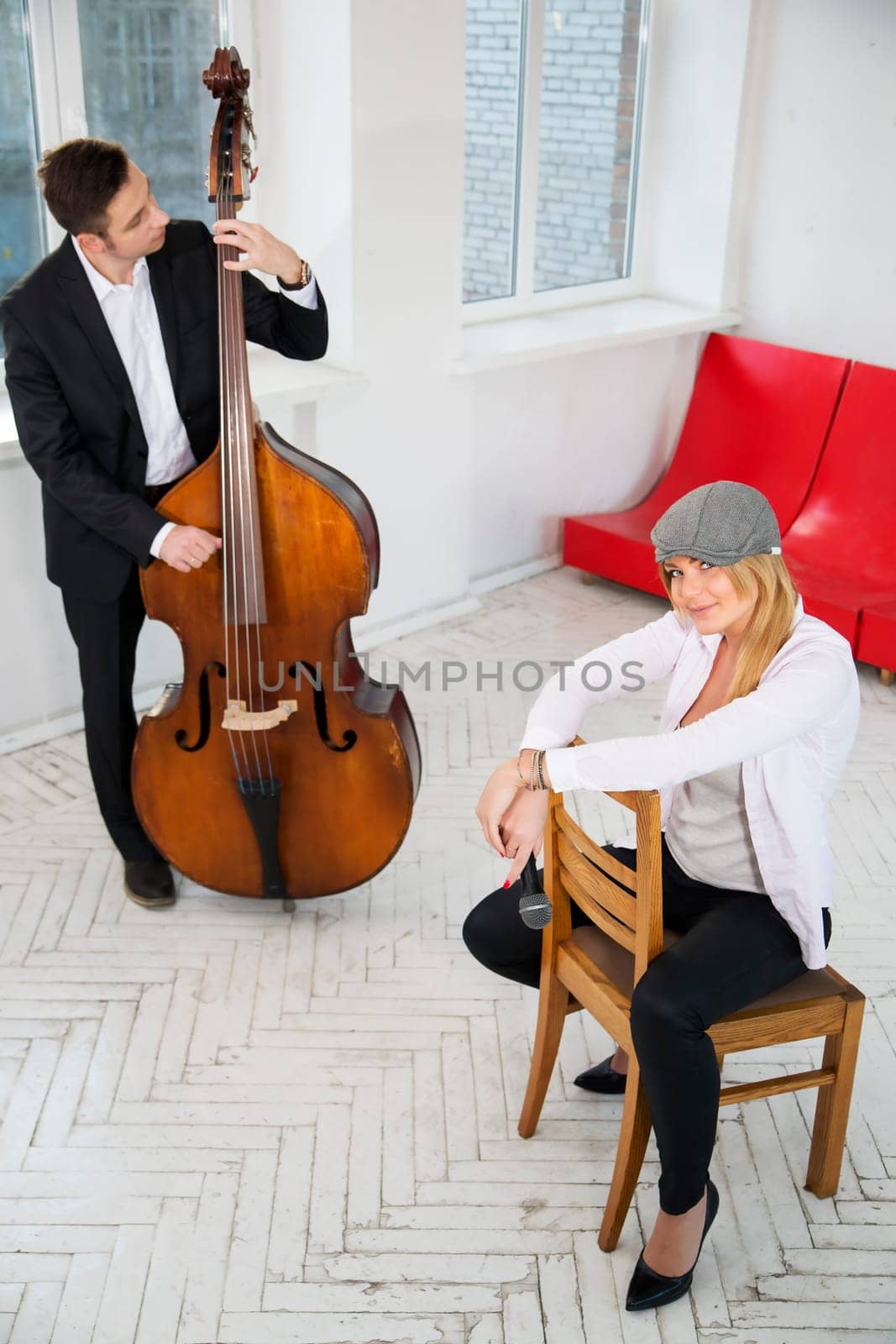 Woman sit backwards on chair and man play