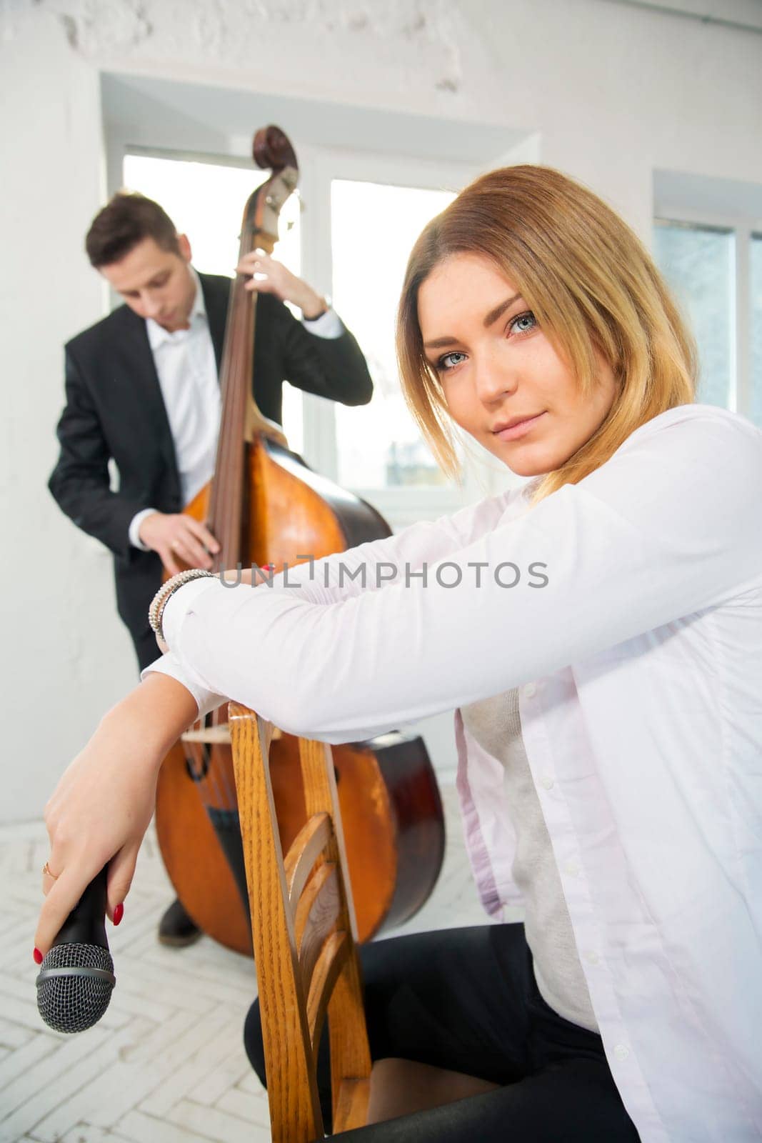 Woman backwards on chair holding microphone at hand