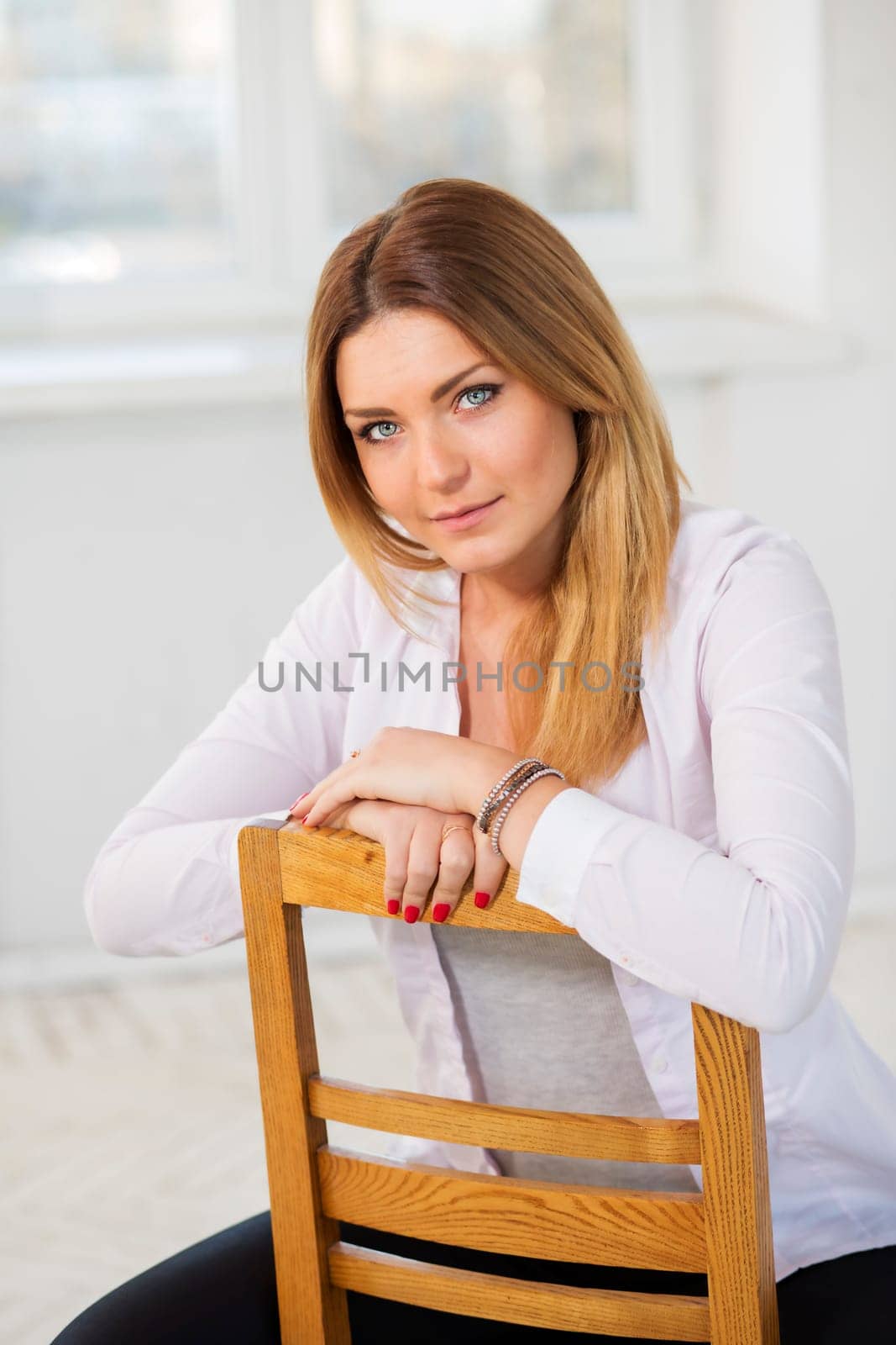 Backwards on wooden chair young woman at studio