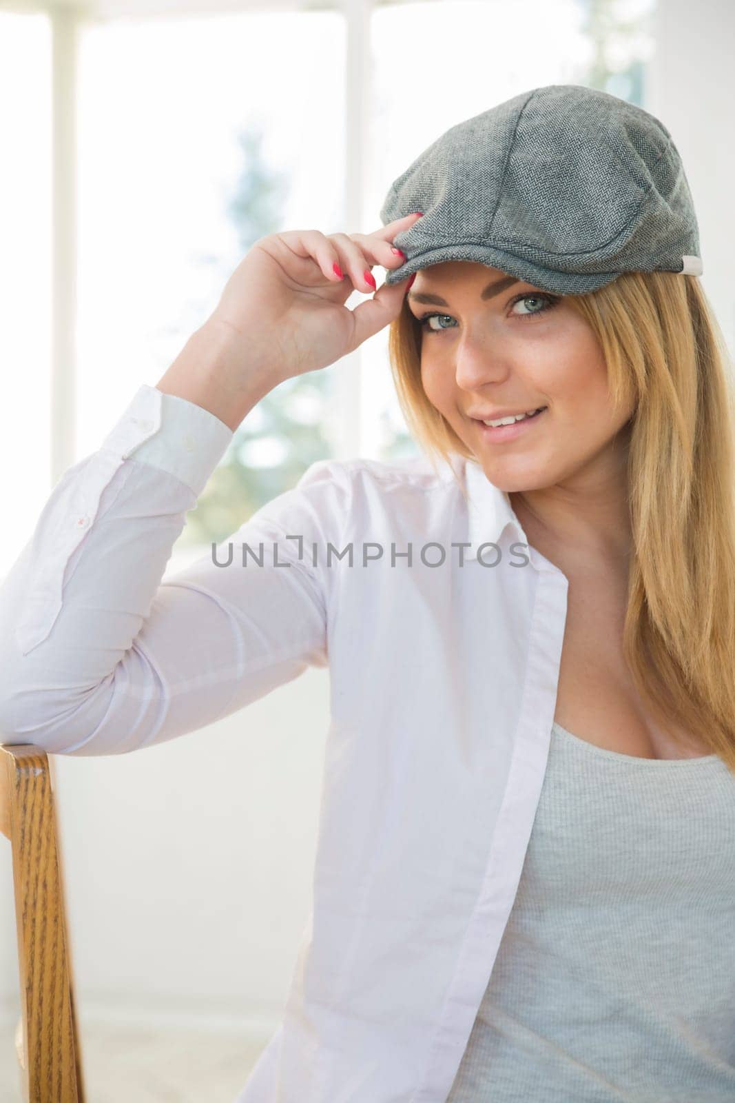 Young woman on chair with stylish grey hat