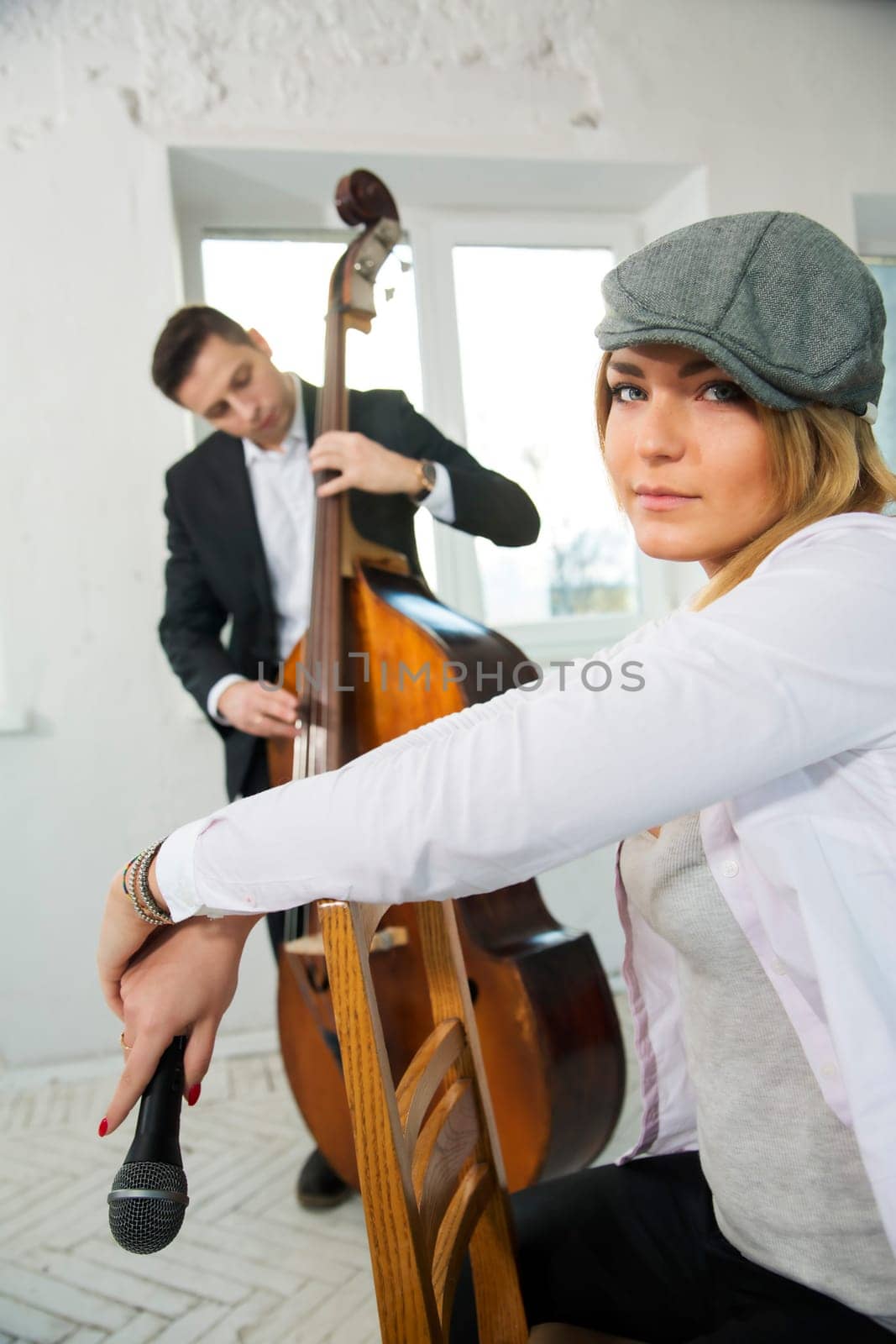 Beautiful woman backwards on chair and contrabas player