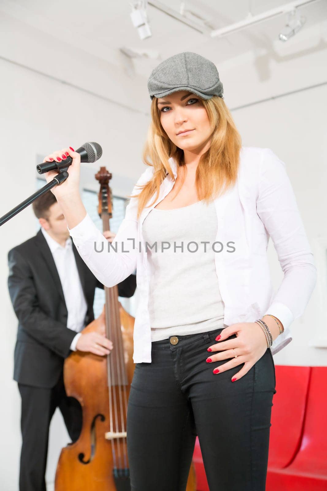 Woman on stage and man play on contrabas