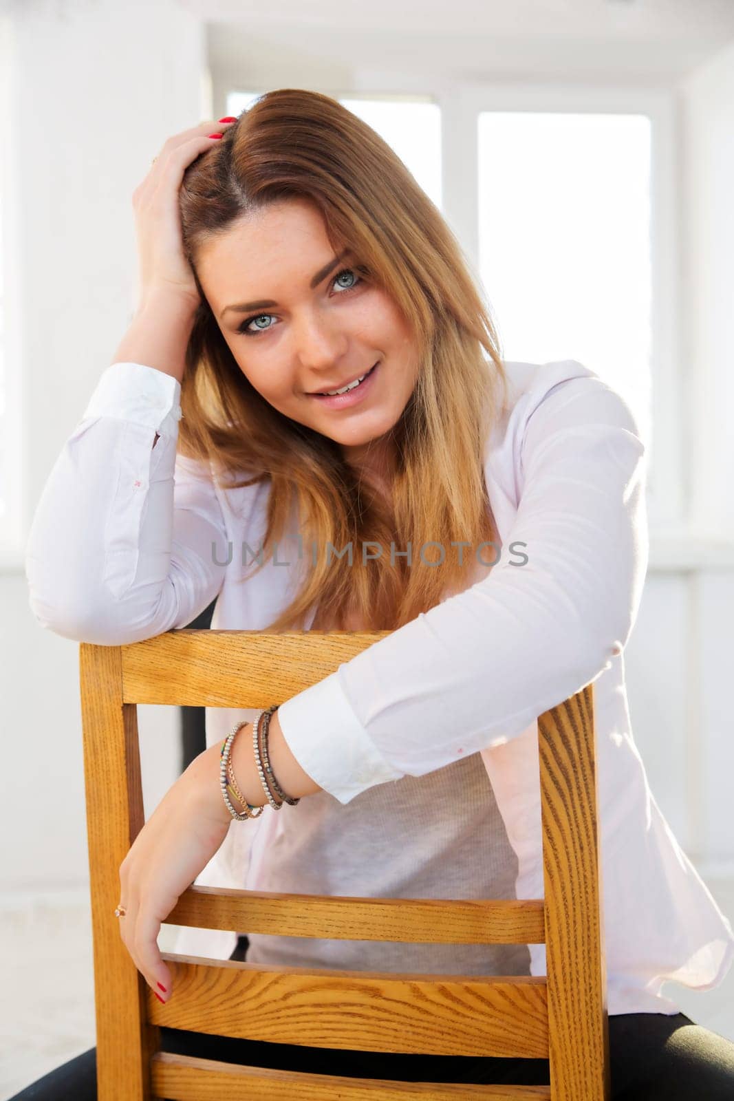 Backwards on wooden chair woman support her head