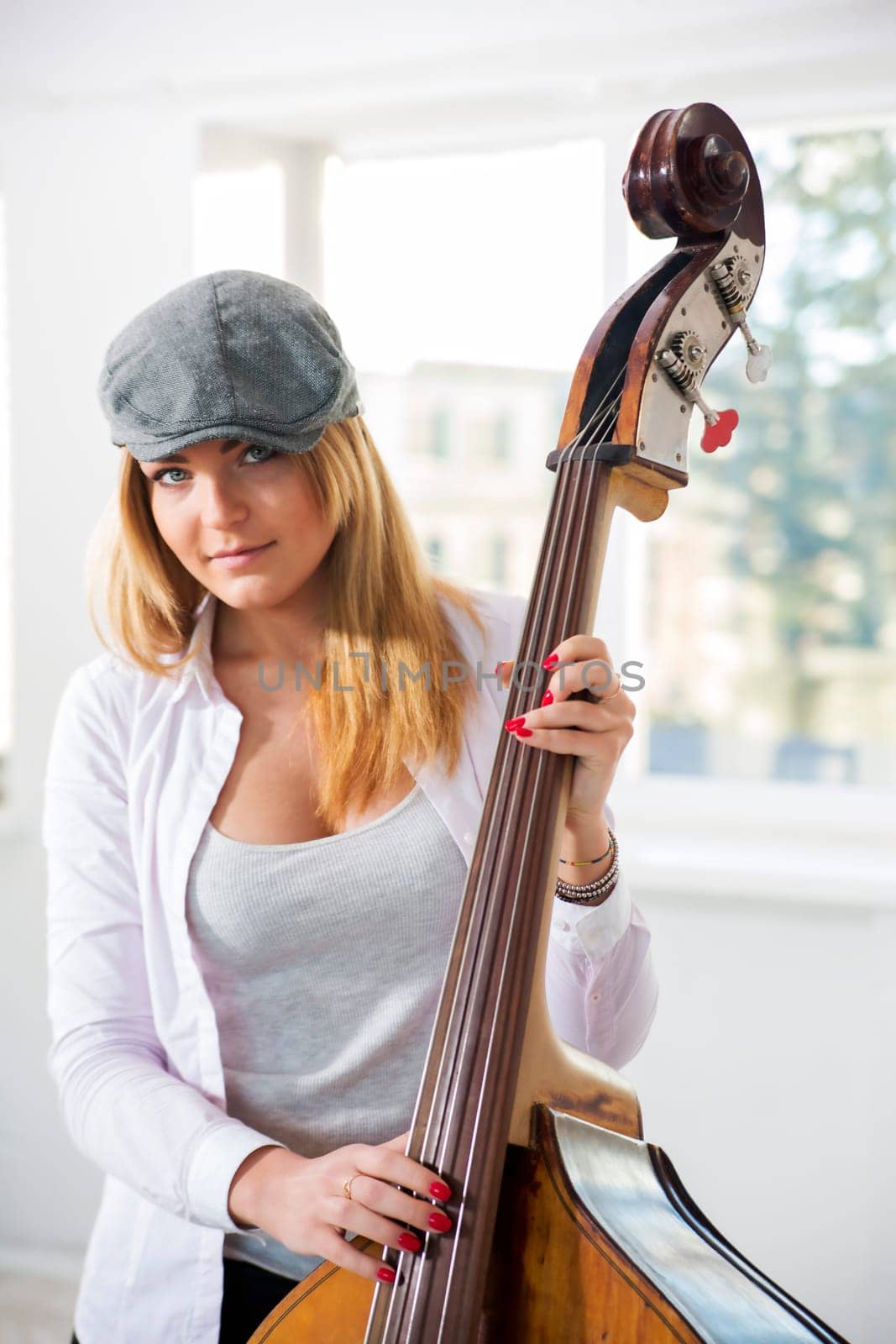 Charming woman is going to play on contrabass