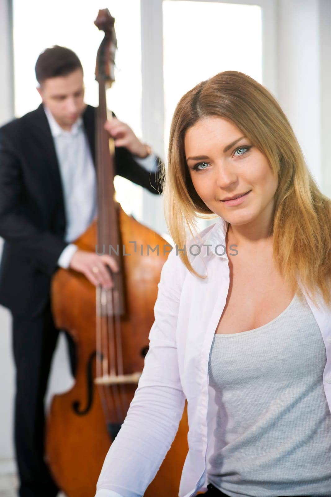 White dressed woman and contrabas player on background