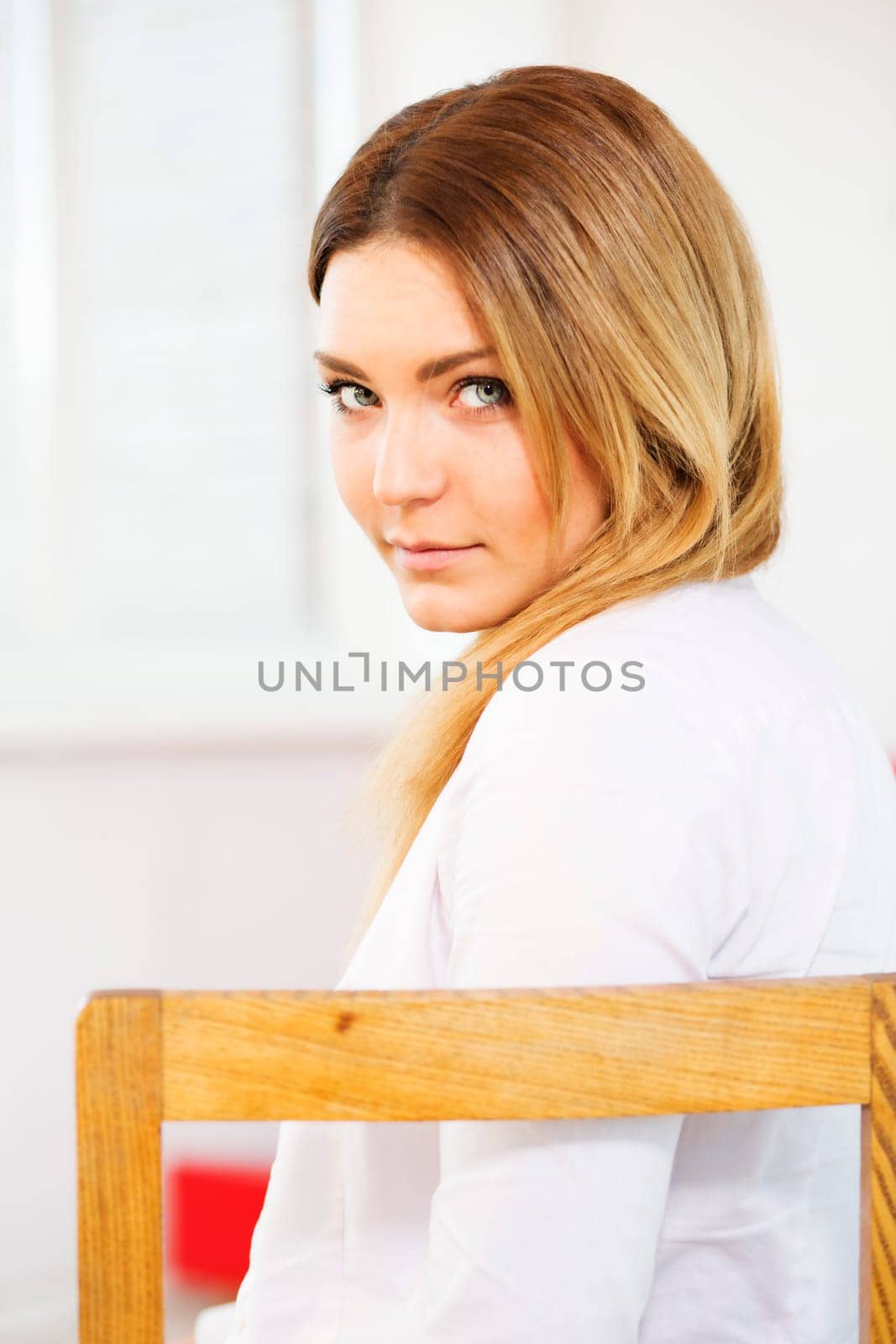 Charming woman on chair with over the shoulder look
