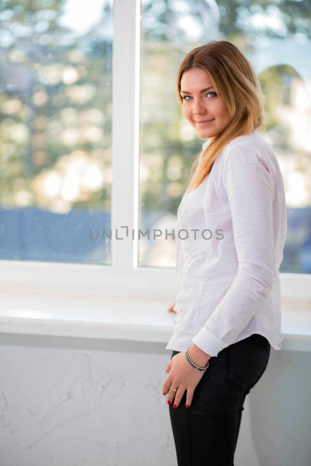 Charming woman in white suit with modest smile