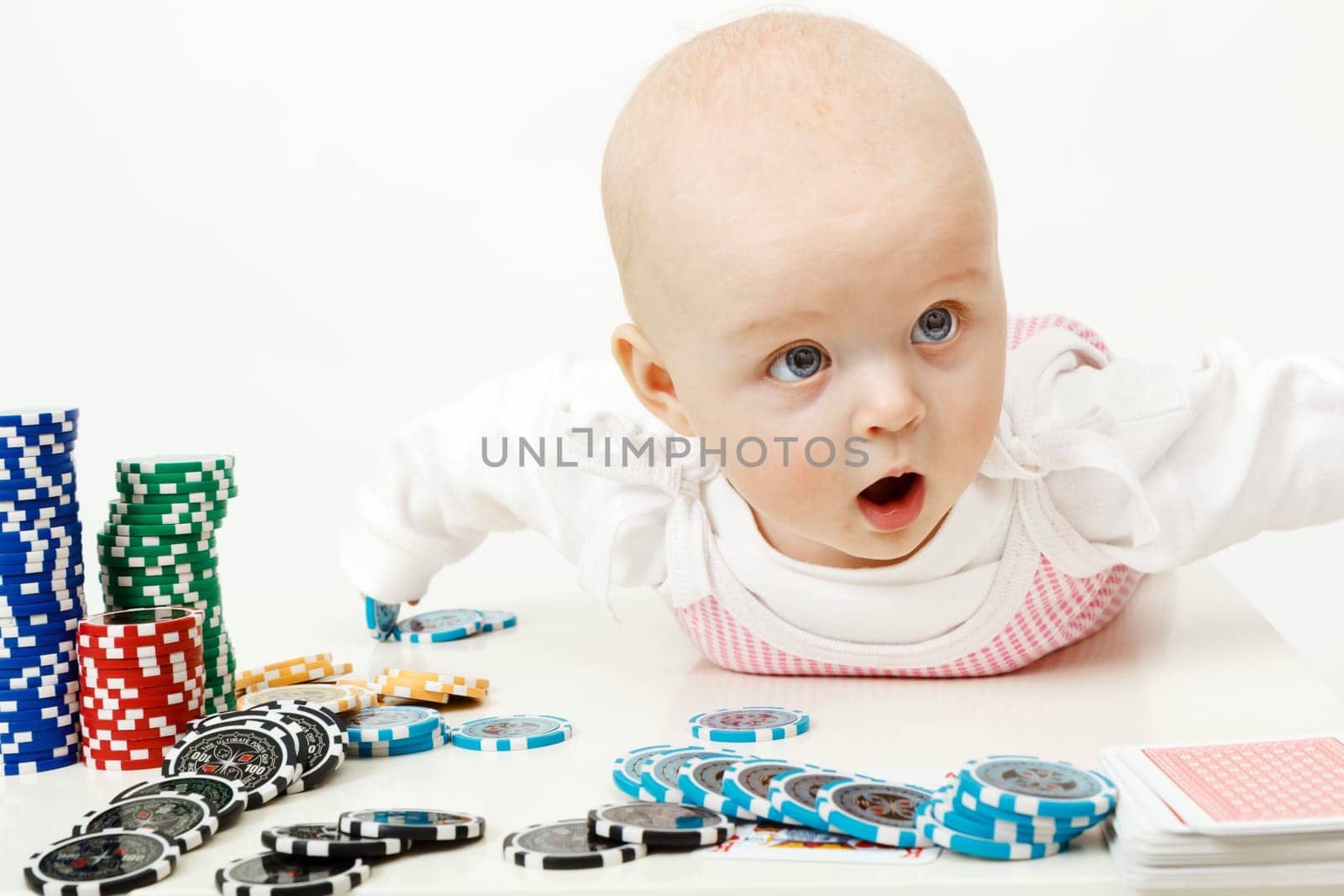 beautiful half-year-old baby playing with playing chips
