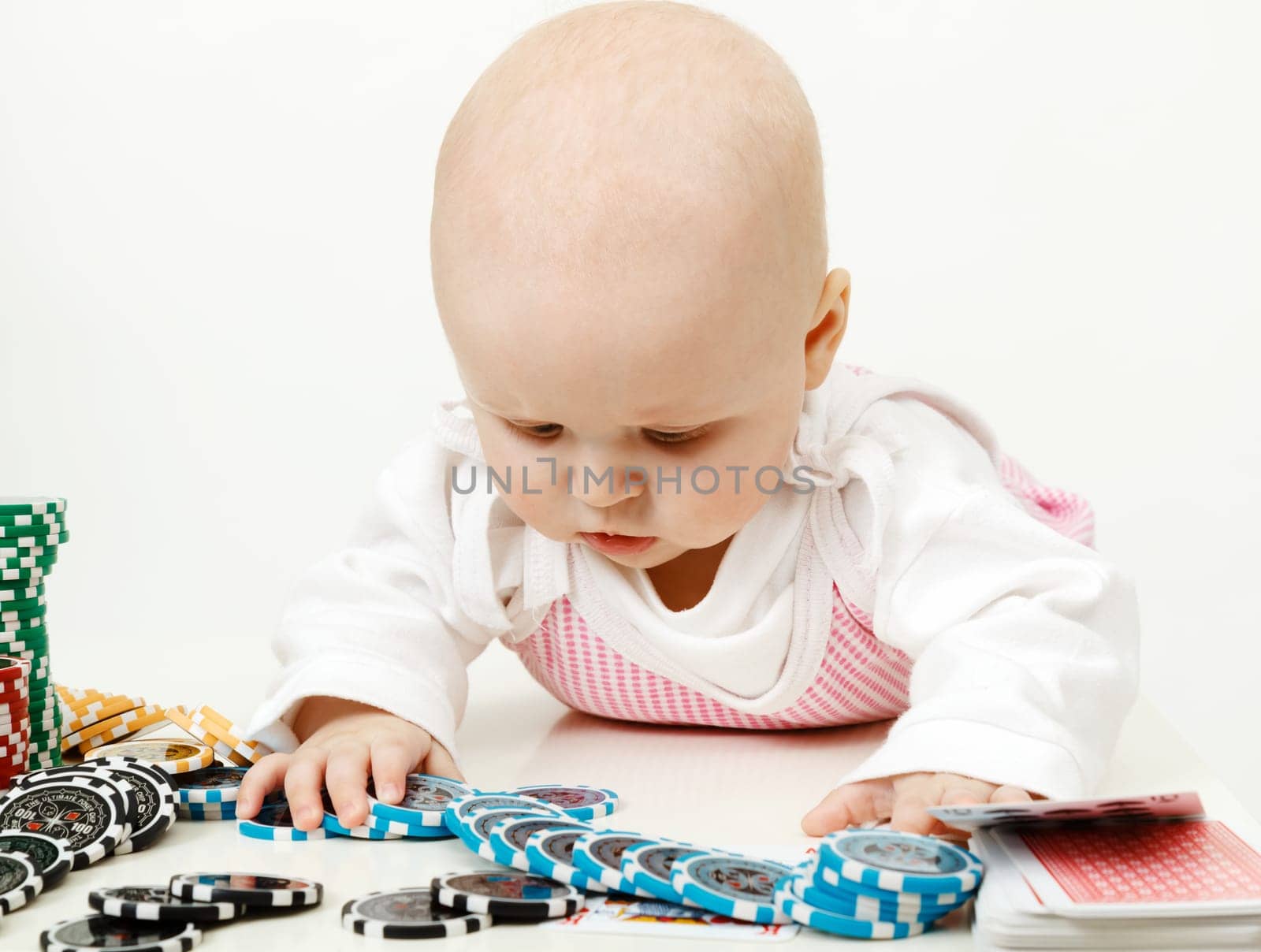beautiful half-year-old baby playing with playing chips
