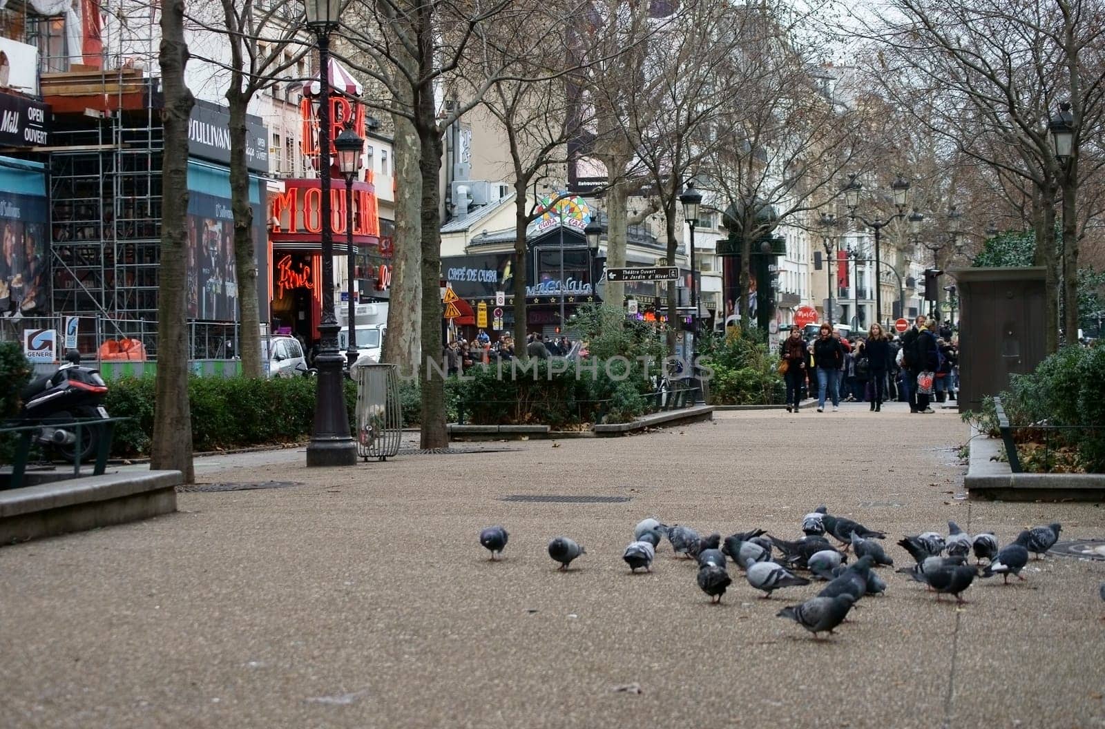 Paris,France –January 01,2014: Holidaymakers pass a street on Boulevard de Clichy opposite the Moulin Rouge on January 1,2014 in Paris.