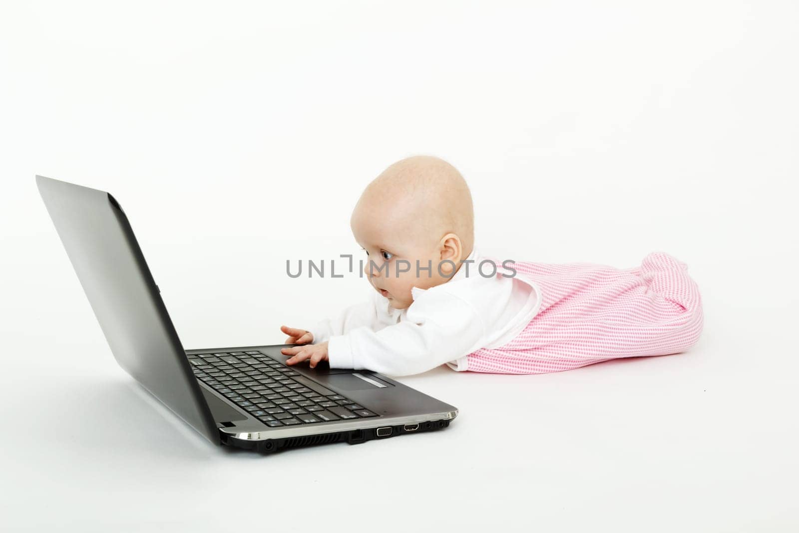 lying on the floor a beautiful baby girl with black laptop