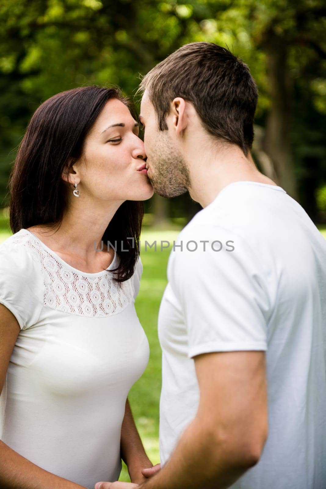 Young happy couple kissing  - outdoor lifestyle portrait